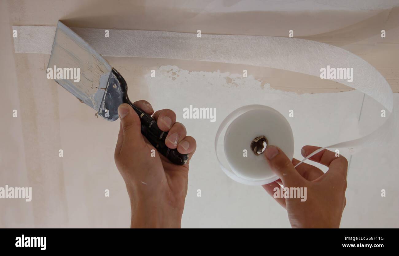 man plastering ceiling repair. Selective focus. Stock Photo