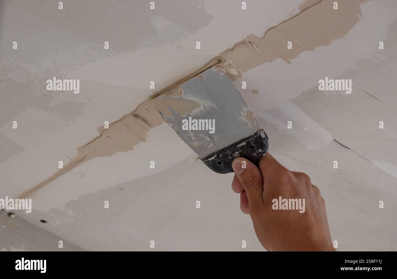 man plastering ceiling repair. Selective focus. Stock Photo