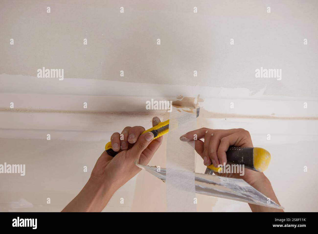 man plastering ceiling repair. Selective focus. Stock Photo