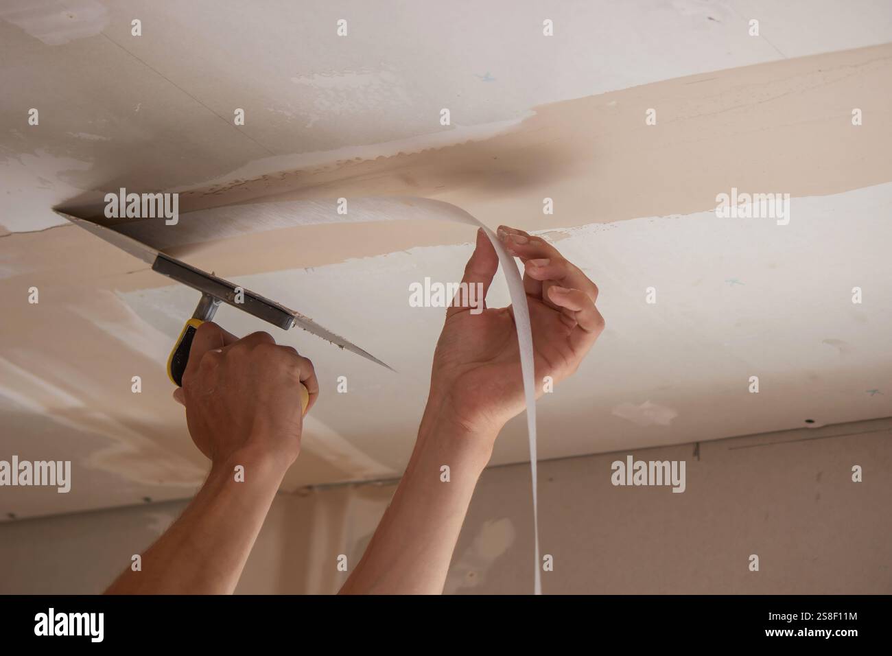 man plastering ceiling repair. Selective focus. Stock Photo