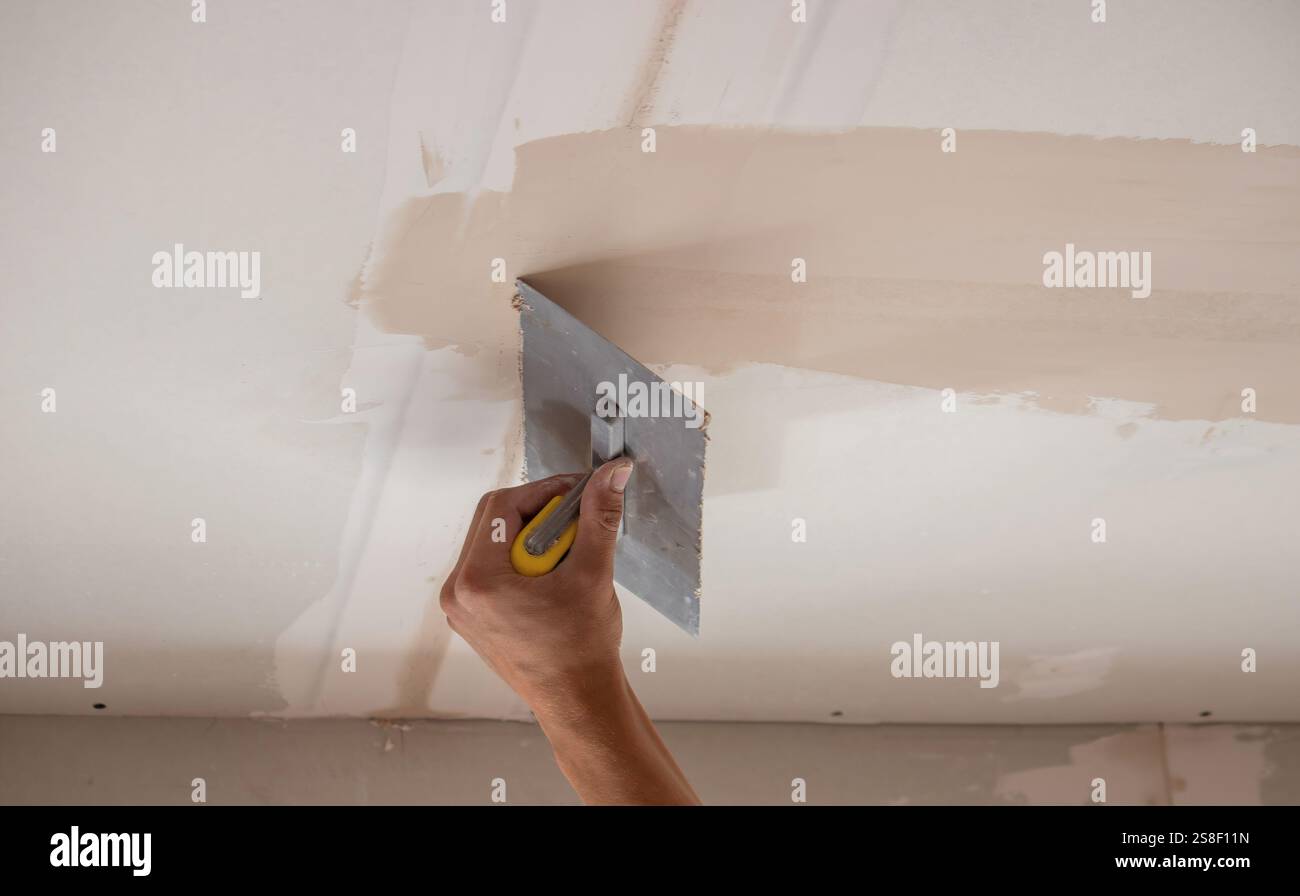 man plastering ceiling repair. Selective focus. Stock Photo