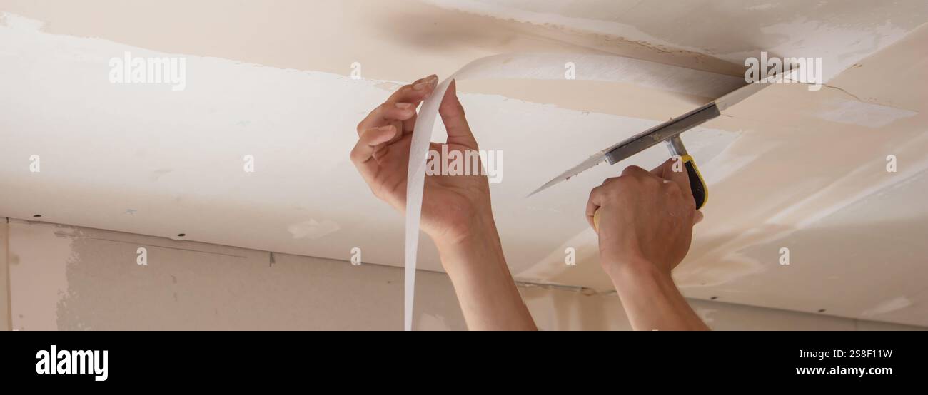 man plastering ceiling repair. Selective focus. Stock Photo