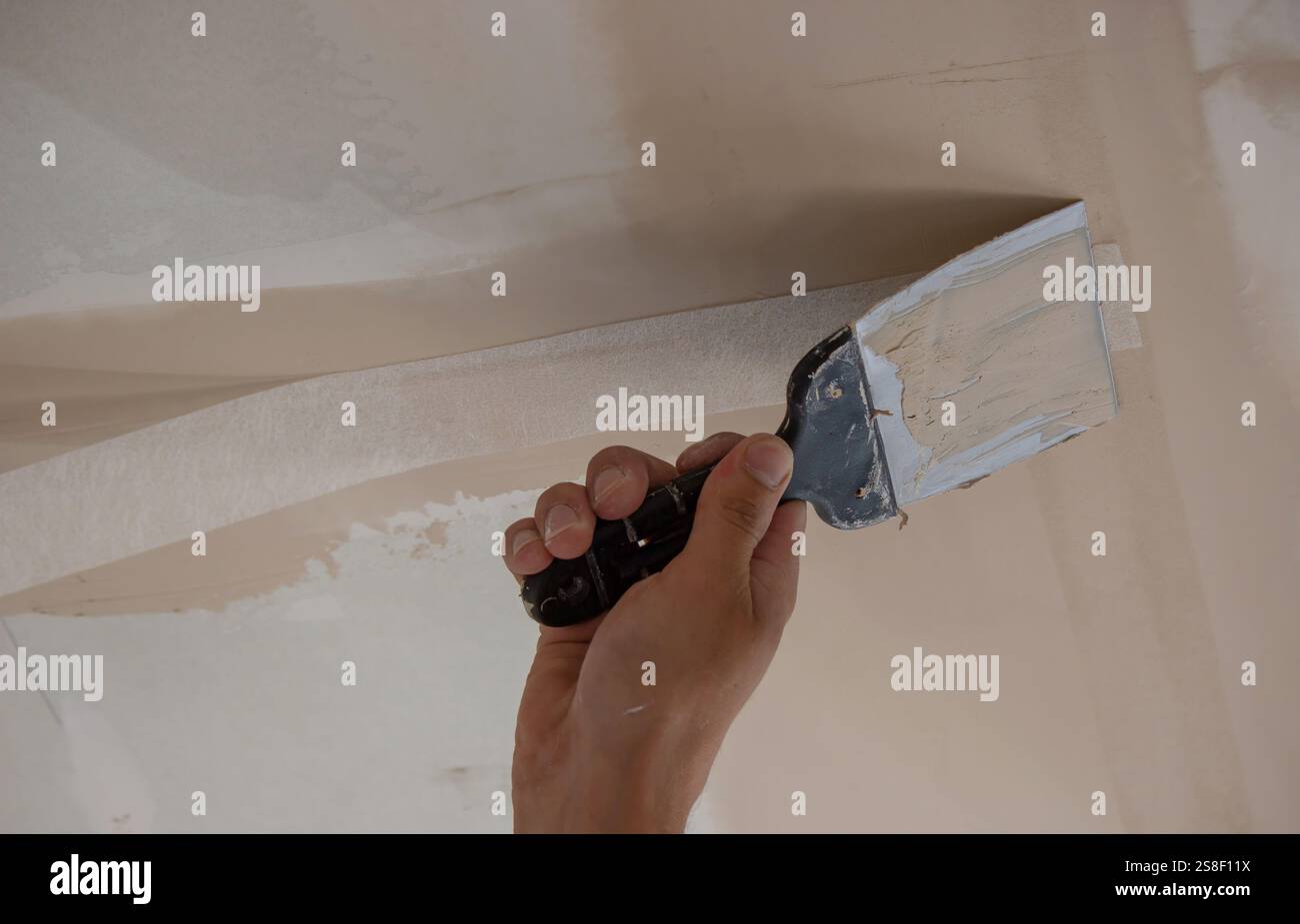 man plastering ceiling repair. Selective focus. Stock Photo