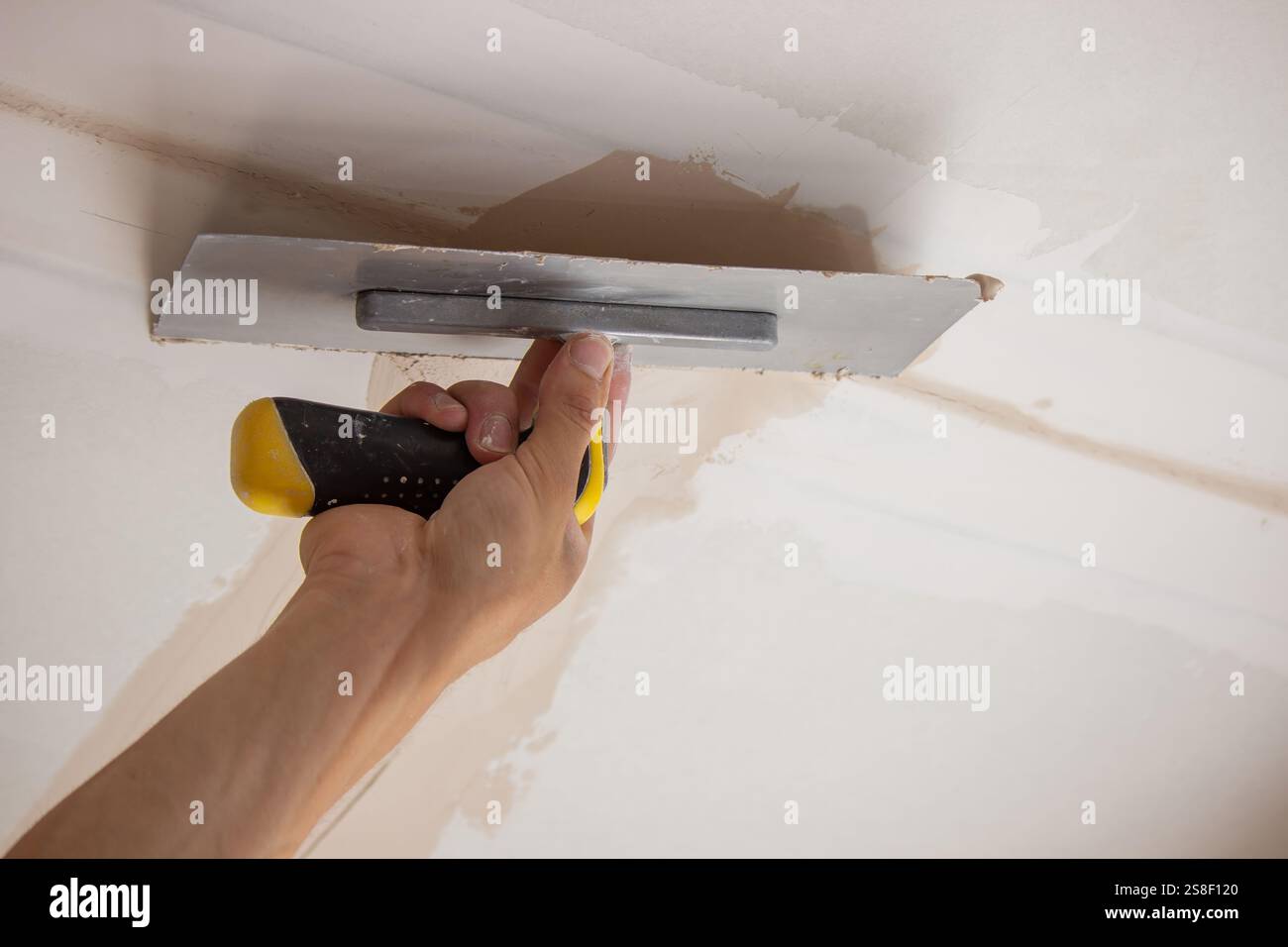 man plastering ceiling repair. Selective focus. Stock Photo