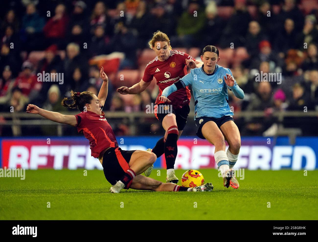 Manchester United's Maya Le Tissier slides in on Manchester City's Lily