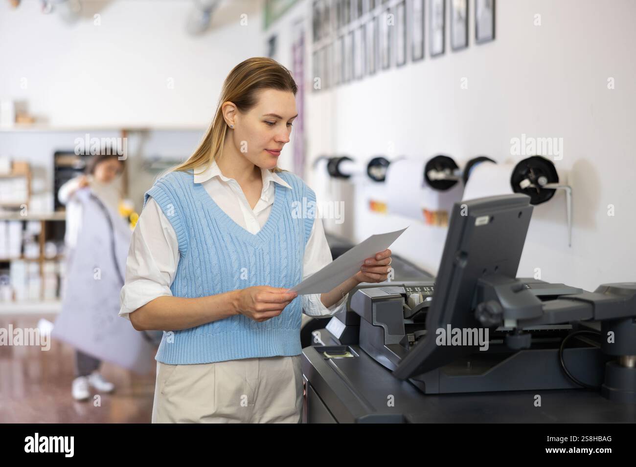 Technician operator calibrating plotter machine, typing on computer keyboard Stock Photo