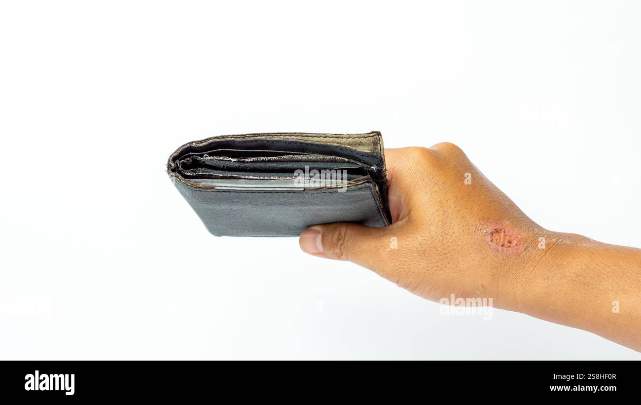 A tanned hand holding an ugly and broken wallet on a white background ...