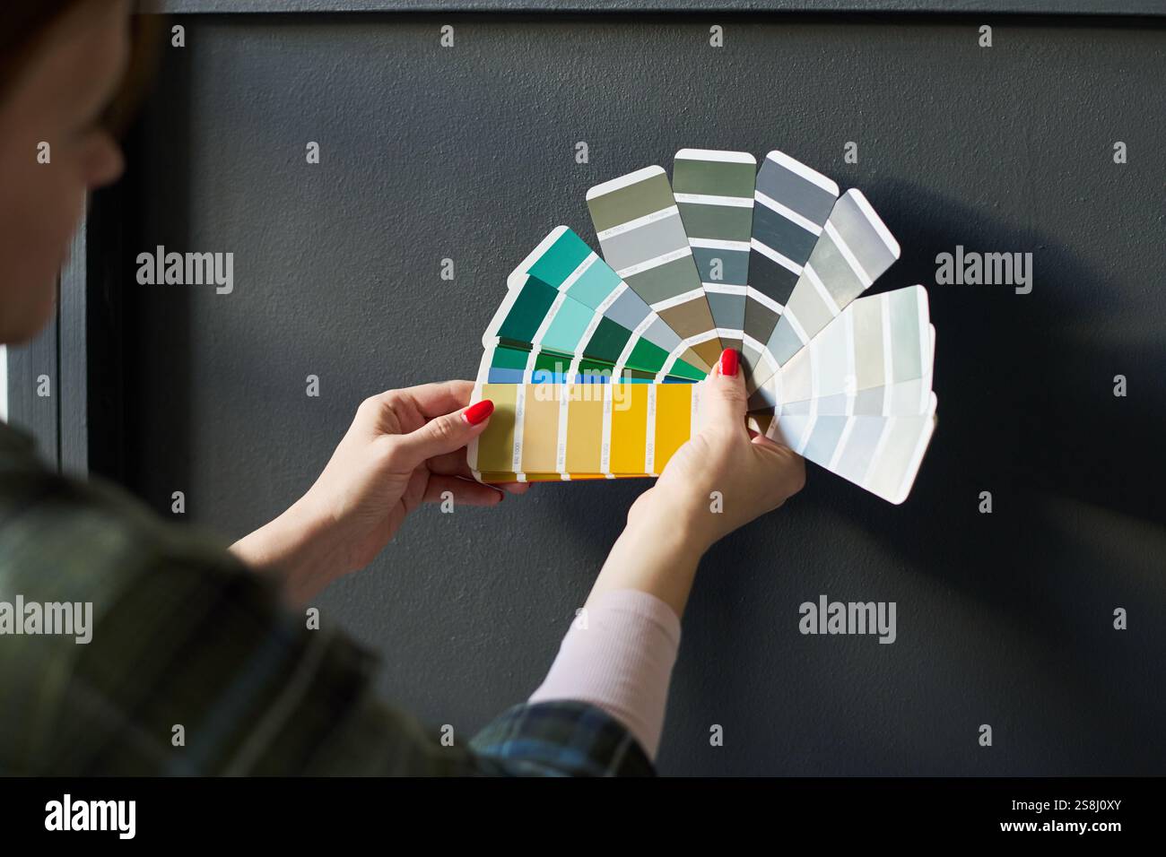 Color Against Focus on hands of young woman holding color palette against grey ...