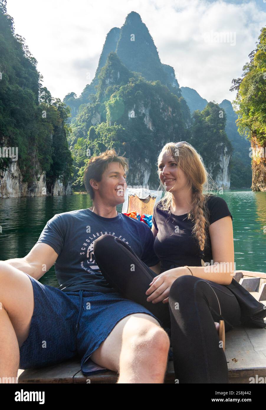 Couple enjoys a boat ride on a serene lake surrounded by towering ...