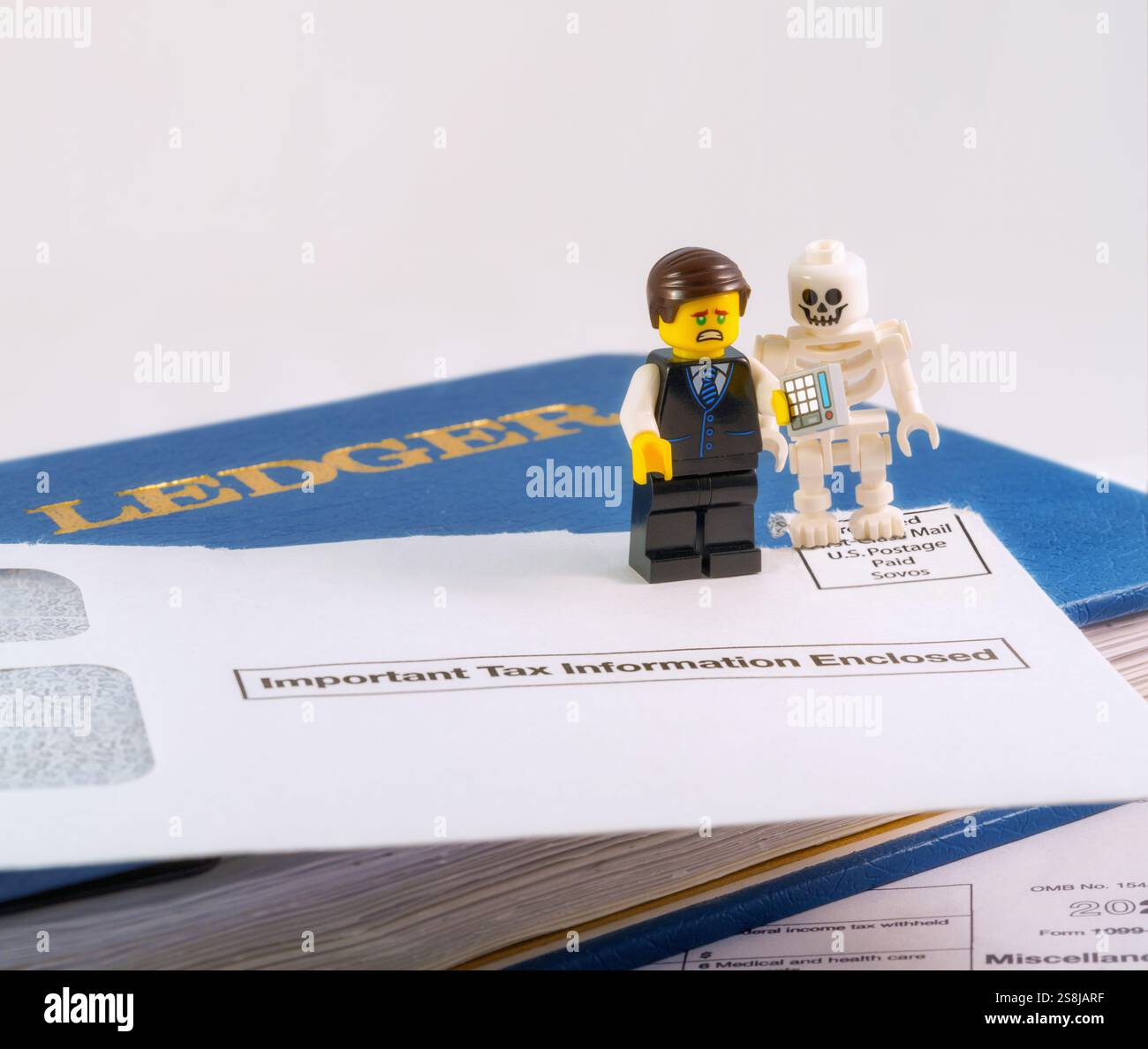 Chappaqua, NY - April 11, 2024: Lego minifigures accountant and skeleton humorous illustration of saying, nothing is certain except death and taxes. Stock Photo