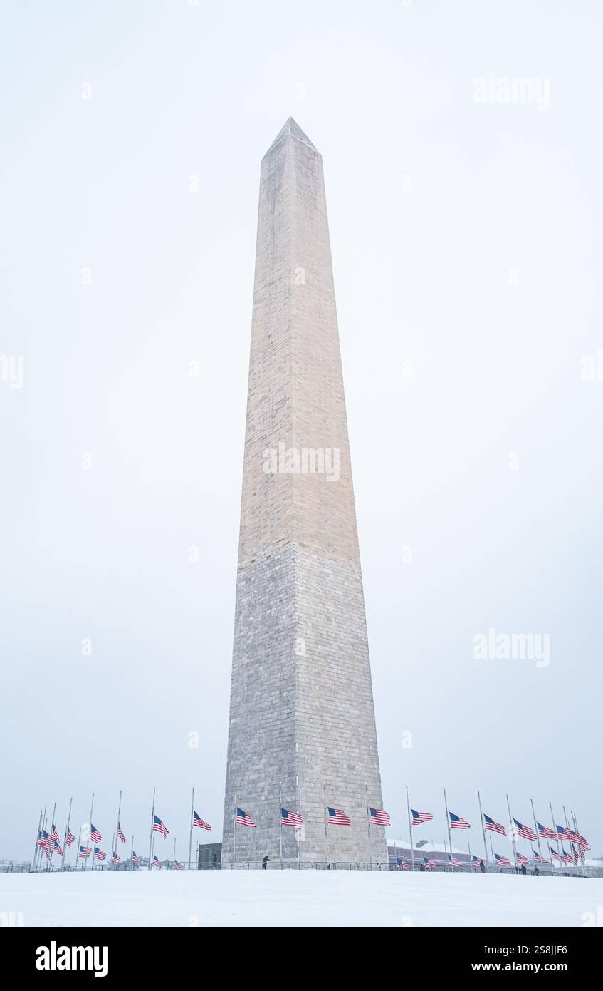 View of the Washington Monument  on a snowy day with American flags. Stock Photo