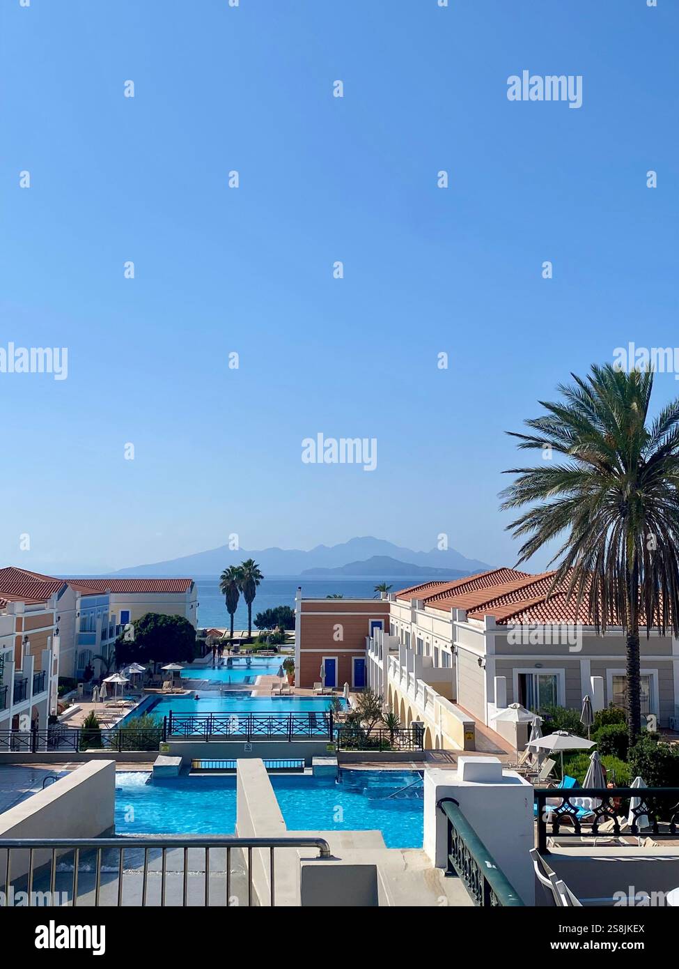 High angle view of buildings against clear blue sky with an island view in the background - Smartphone Captured Stock Image