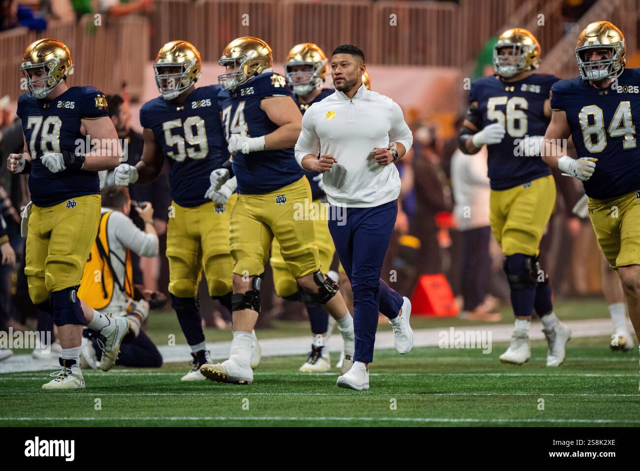 Notre Dame head coach Marcus Freeman runs onto the field with his