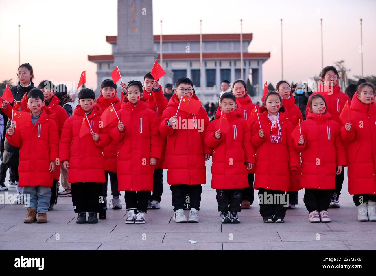Tourists watch the flag raising ceremony at Tiananmen Square in Beijing