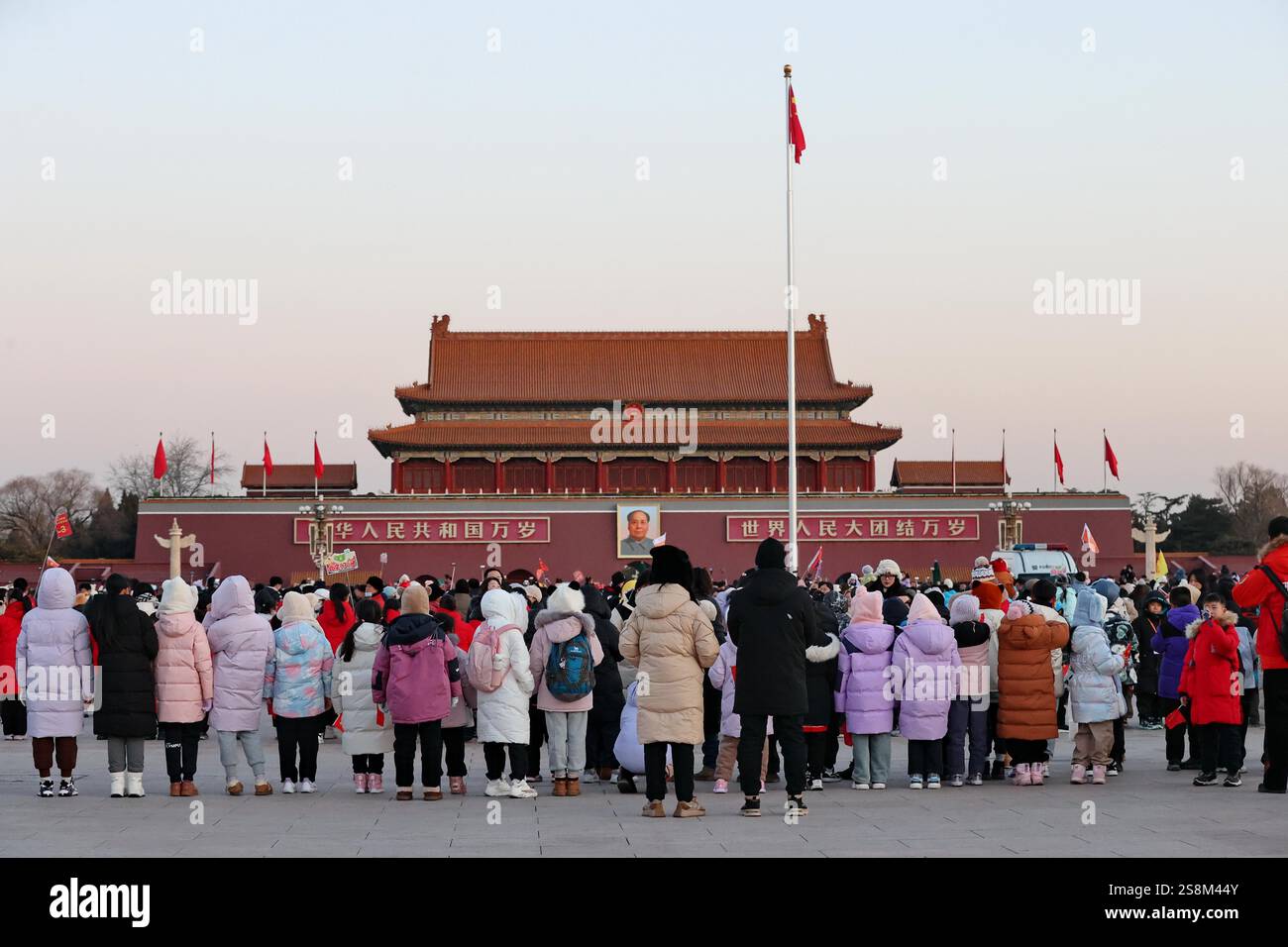 Tourists watch the flag raising ceremony at Tiananmen Square in Beijing