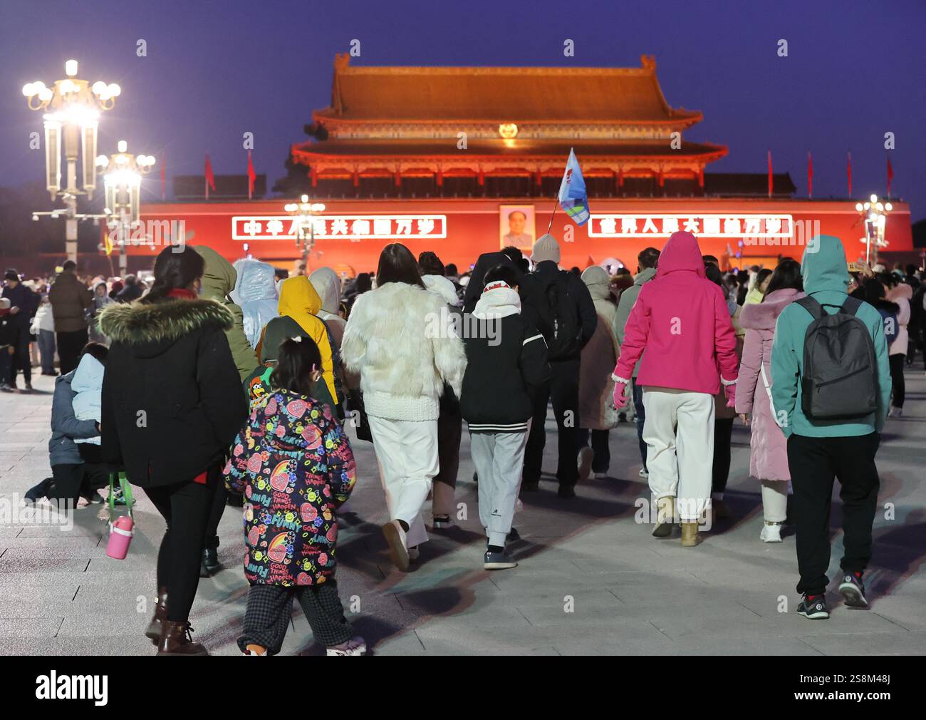 Tourists watch the flag raising ceremony at Tiananmen Square in Beijing