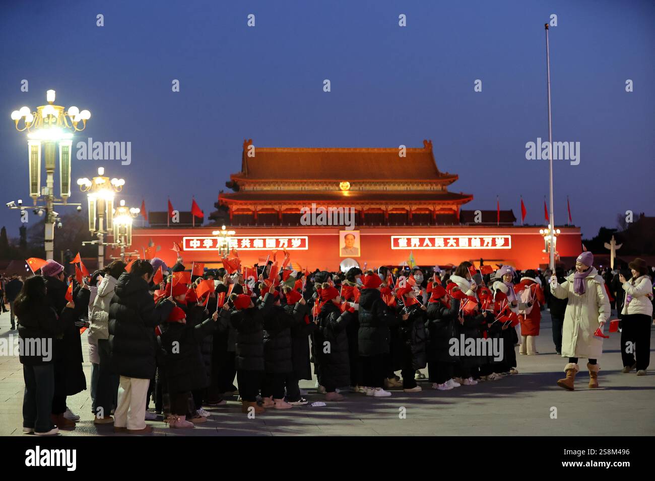 Tourists watch the flag raising ceremony at Tiananmen Square in Beijing