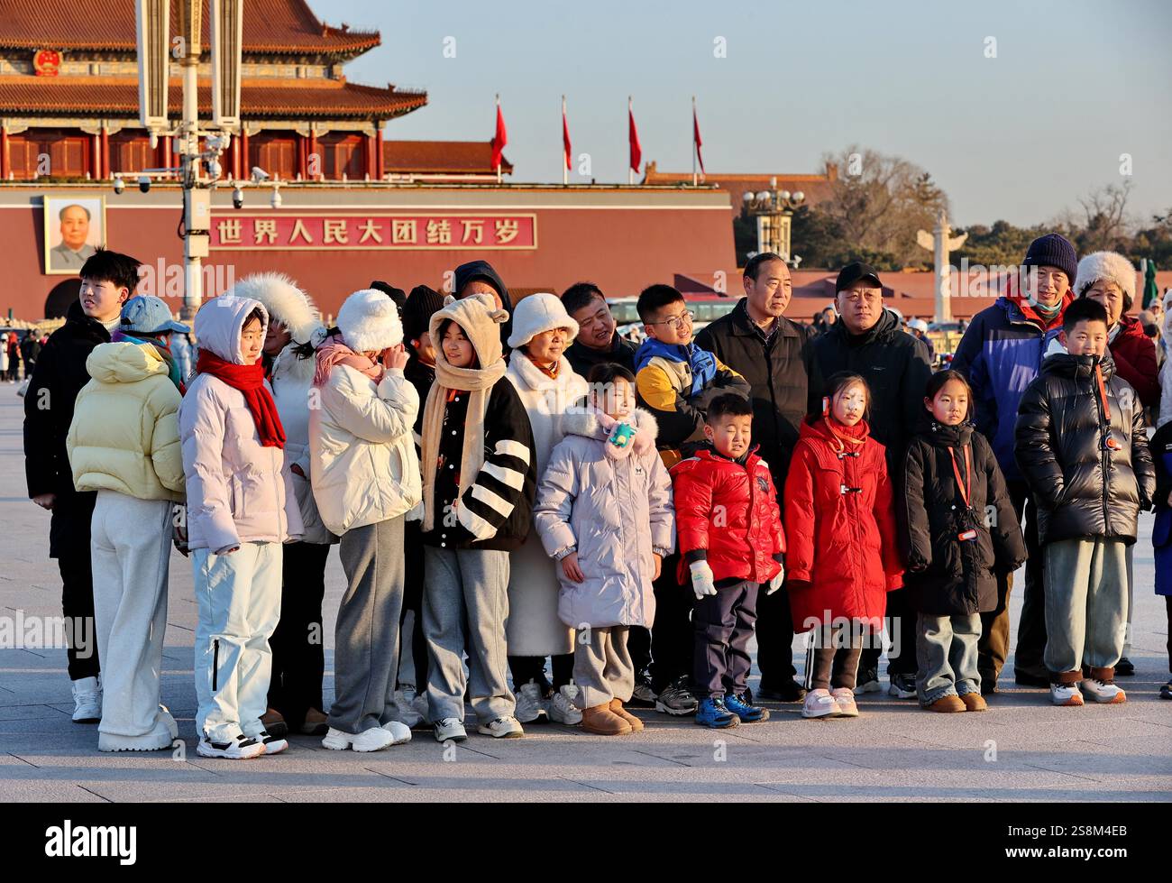 Tourists watch the flag raising ceremony at Tiananmen Square in Beijing