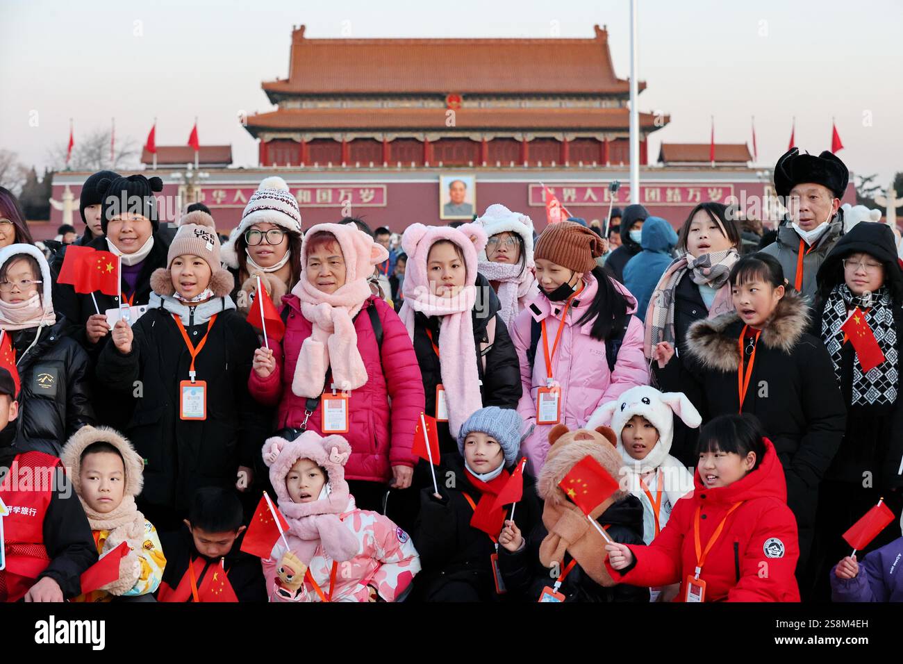 Tourists watch the flag raising ceremony at Tiananmen Square in Beijing