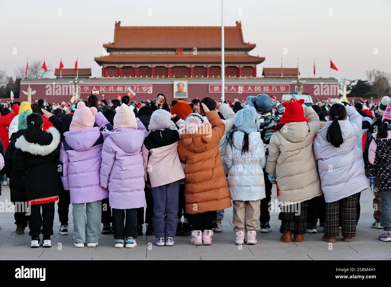 Tourists watch the flag raising ceremony at Tiananmen Square in Beijing