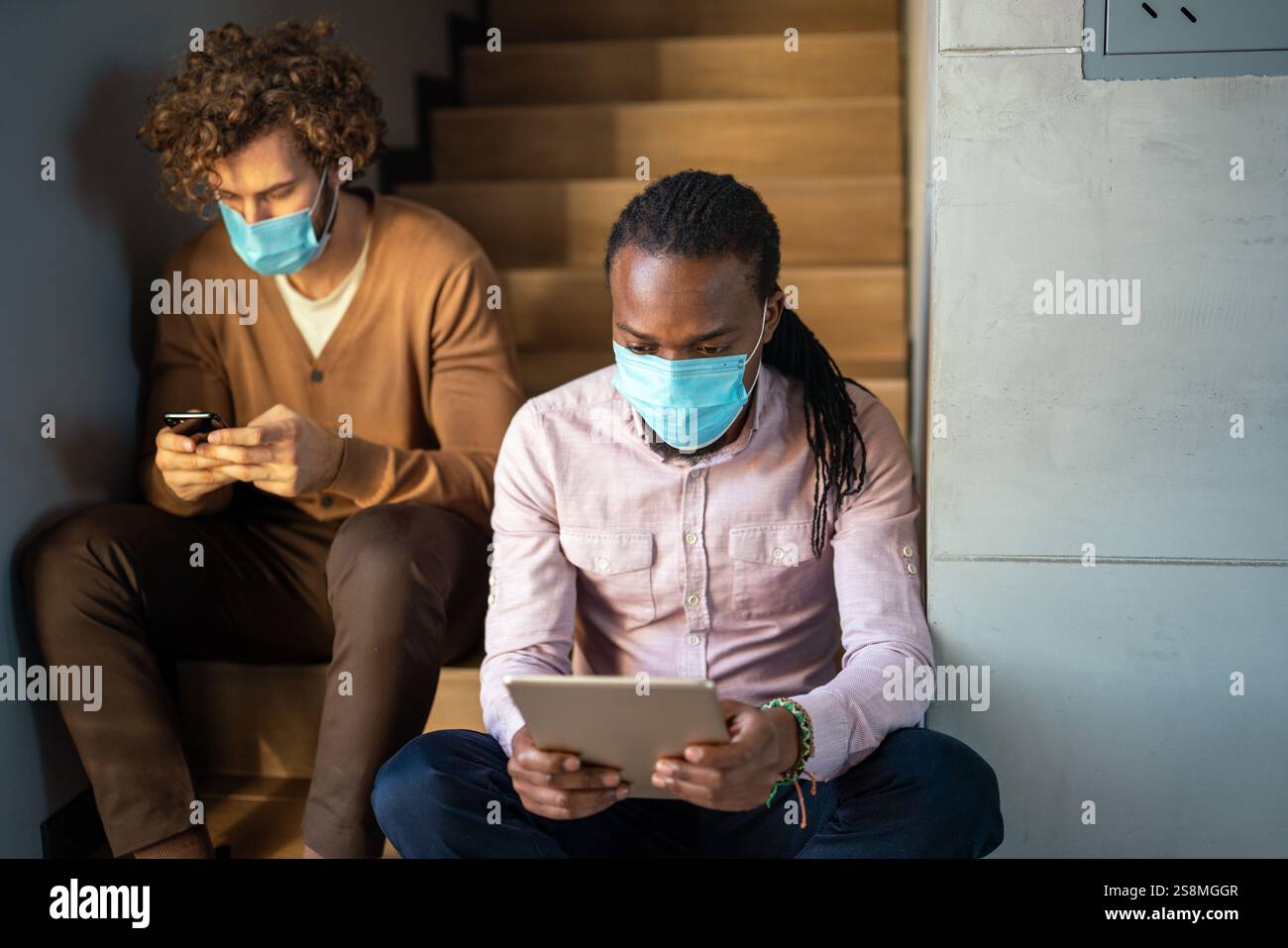 Busy business men, programmers software developer engineer working on computer in office in masks Stock Photo