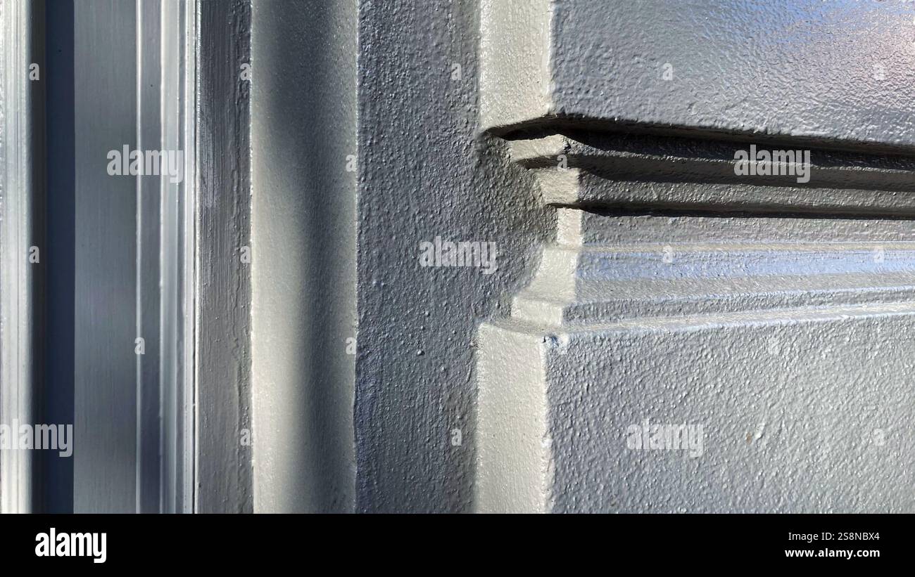 Detailed view of an architectural building ornament featuring fine stucco molding, textural surface, and natural lighting creating shadow effects. - Smartphone Captured Stock Image