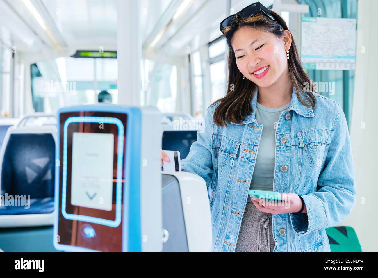 Smiling chinese Woman Validating Ticket Inside Public Transport with ...