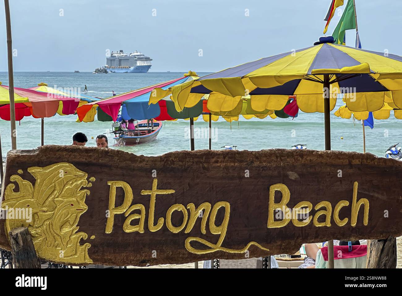 Patong beach on the Indian Ocean with parasol and cruise ship. Patong, Kathu, Phuket Island, Thailand, Asia Stock Photo