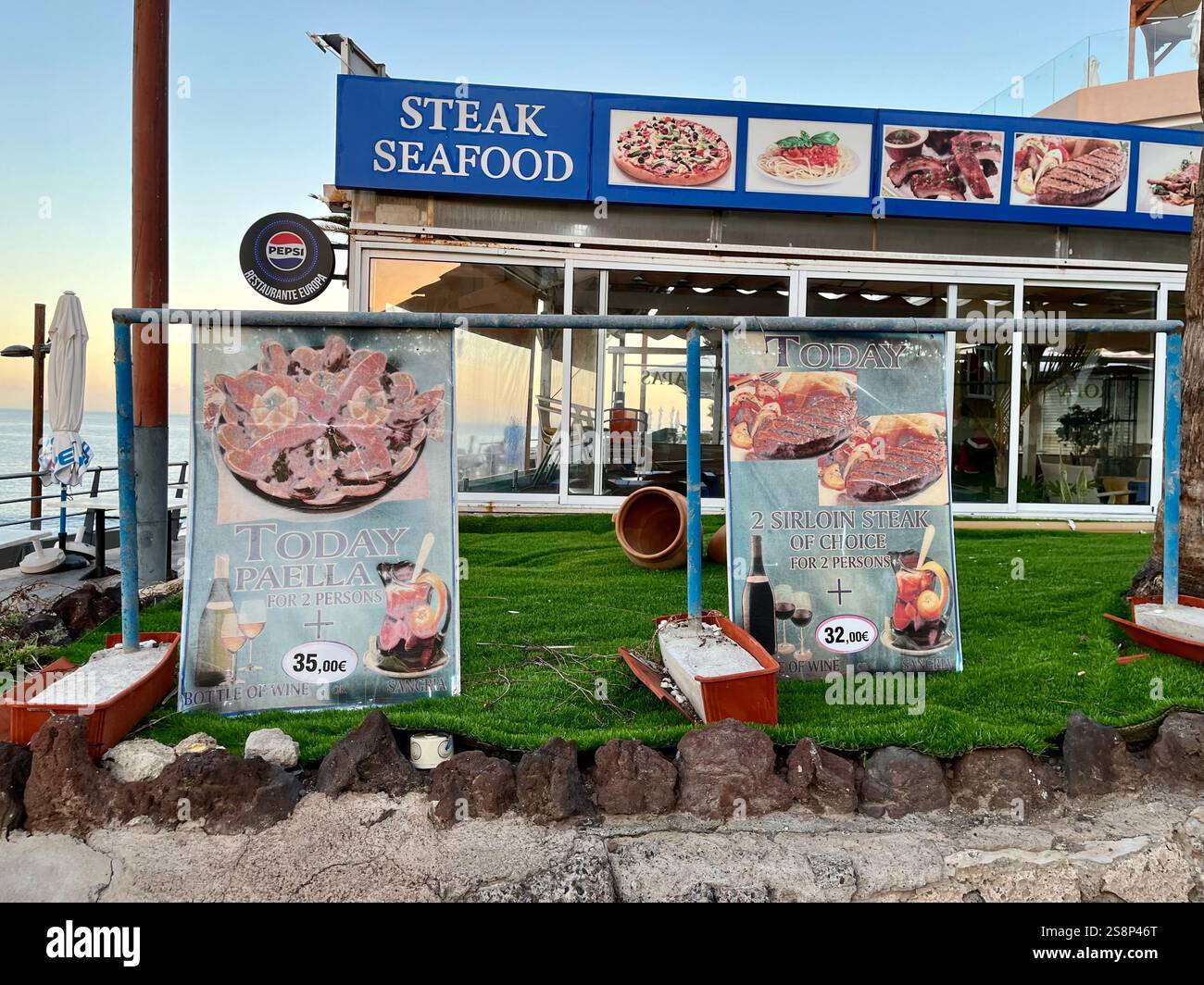 Restaurante Europa in Costa Adeje, with faded signs advertising Paella and Sirloin Steak. Tenerife, Canary Islands, Spain. 14th January 2025. - Smartphone Captured Stock Image