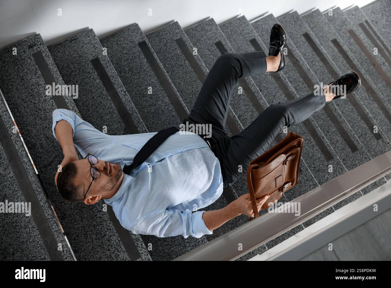 Man with injured head on stairs in building after fall, above view ...