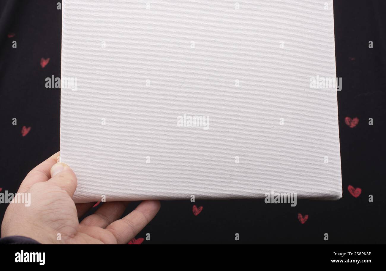 White blank canvas on black background with red hearts Stock Photo