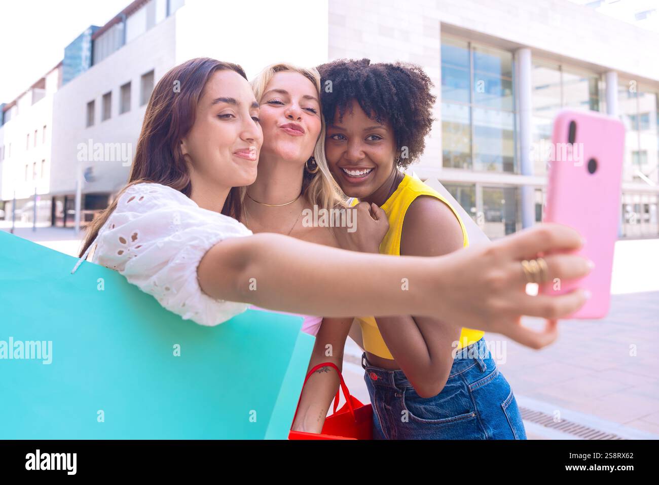 Three happy young women taking a selfie together in a city street Stock ...
