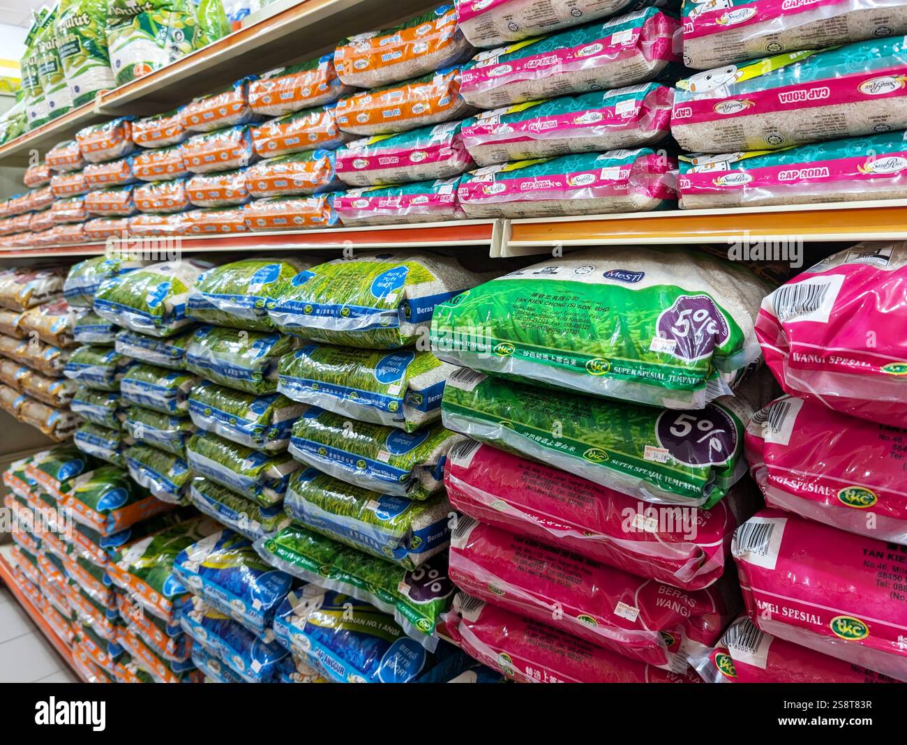 Kota Kinabalu, Malaysia - Jan 20, 2025: Various brand of rice packages displayed for sale on shelves in Malaysian supermarket - Smartphone Captured Stock Image