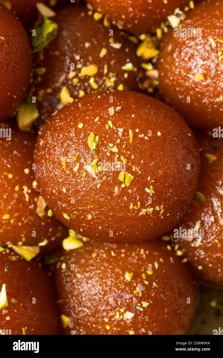 Homemade Indian Gulab Jamun Dessert in Syrup with Pistacchios Stock Photo