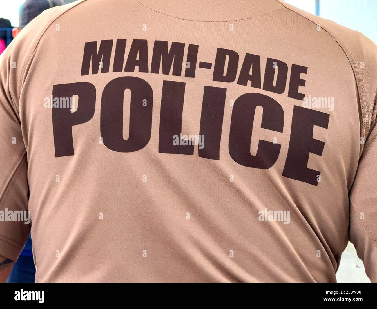 Miami, Florida, USA - 4 January 2024: Sign on the back of the shirt uniform of an officer of the Miami-Dade Police Department - Smartphone Captured Stock Image