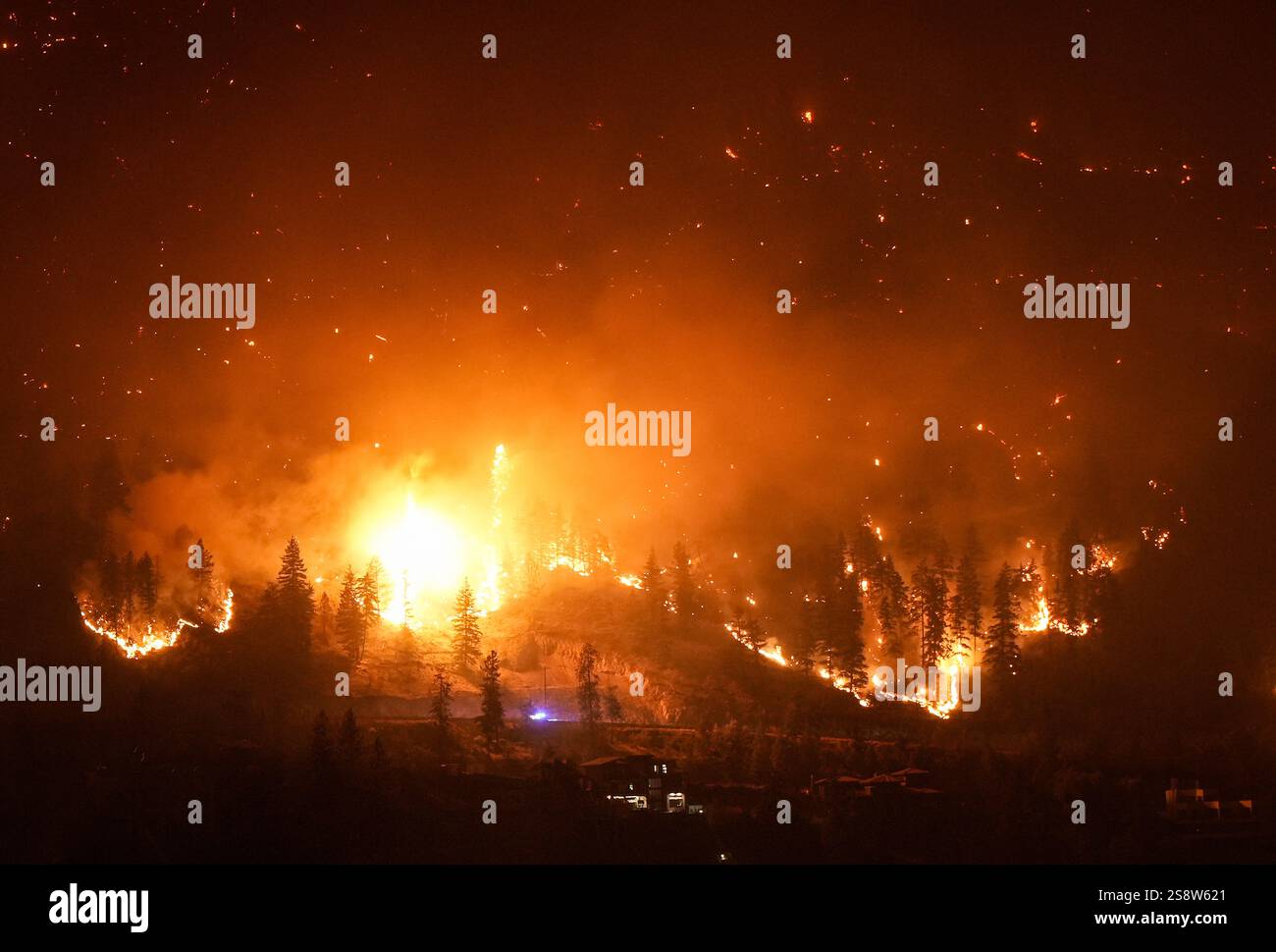 The McDougall Creek wildfire burns on the mountainside above lakefront ...