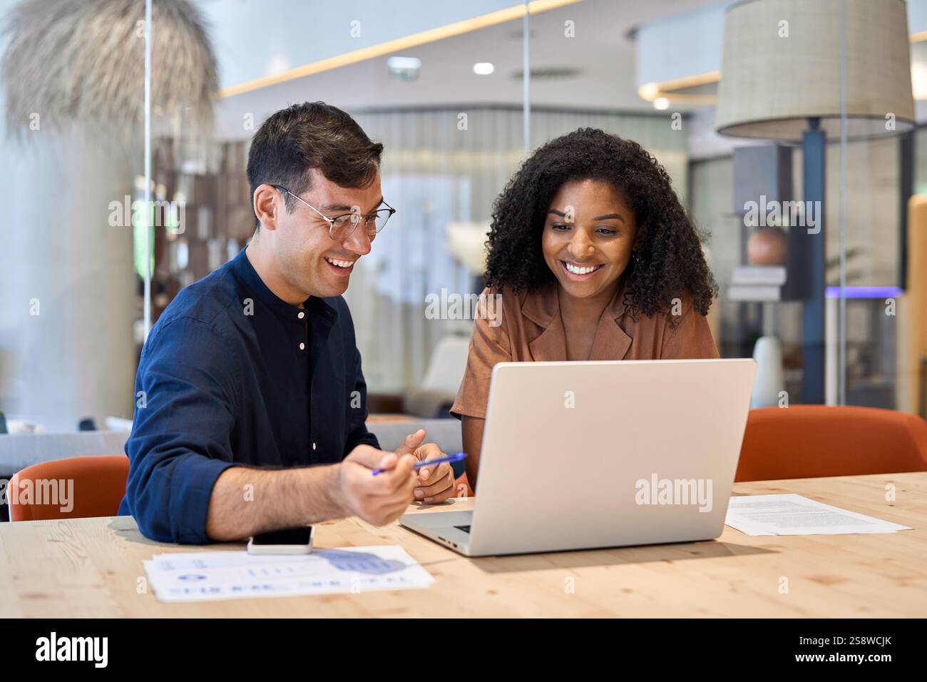 Smiling team professional employees working together on computer in office. Stock Photo