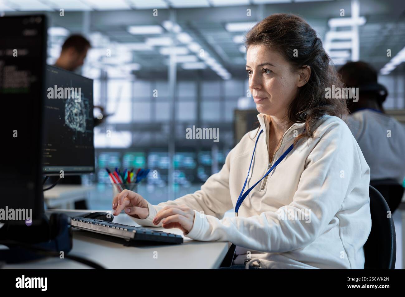 Technician using computer to do maintenance on artificial intelligence neural networks. System administrator using AI system aiding in processing and transmitting information Stock Photo