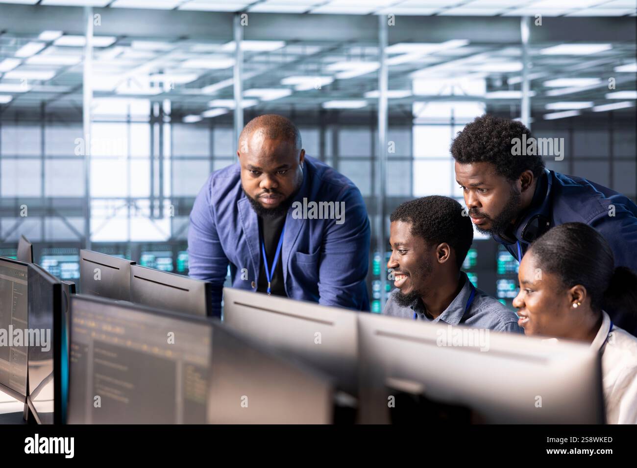 Management executive checking on data center employees creating technical documentation for software applications. Team leader supervising IT workers in server room maintaining databases Stock Photo