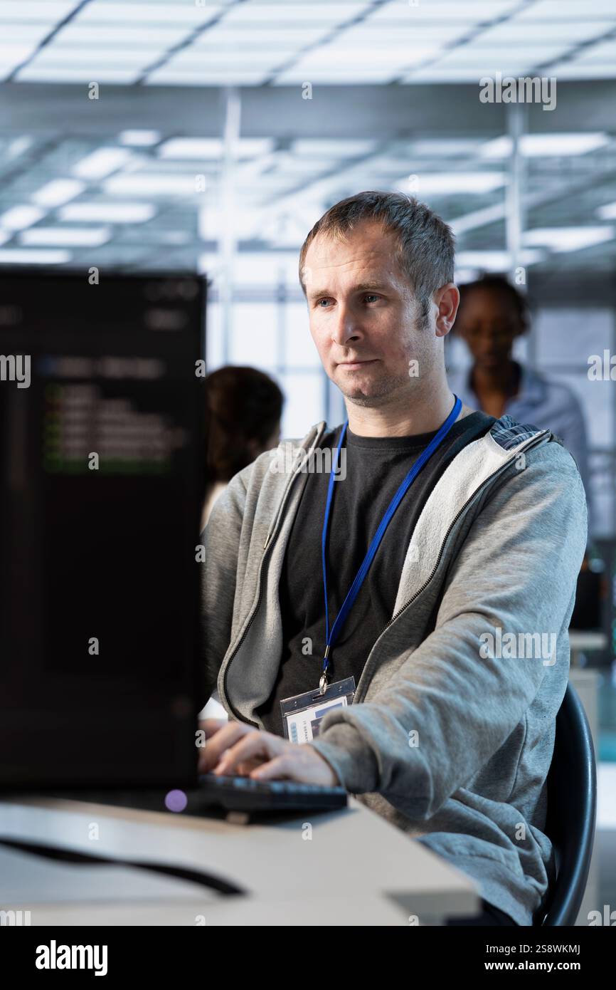 IT professional optimizing data center gear for maximum efficiency and uptime. Software developer in server hub maintaining optimal network performance, performing backups Stock Photo