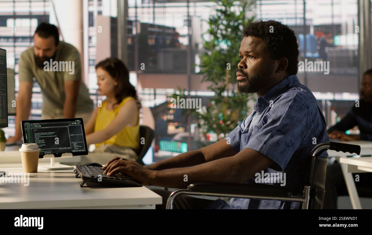 Man with paraplegia conducting code review to fix errors, identifying potential performance and technical issues with software. IT professional with disability in wheelchair optimizing code, camera A Stock Photo