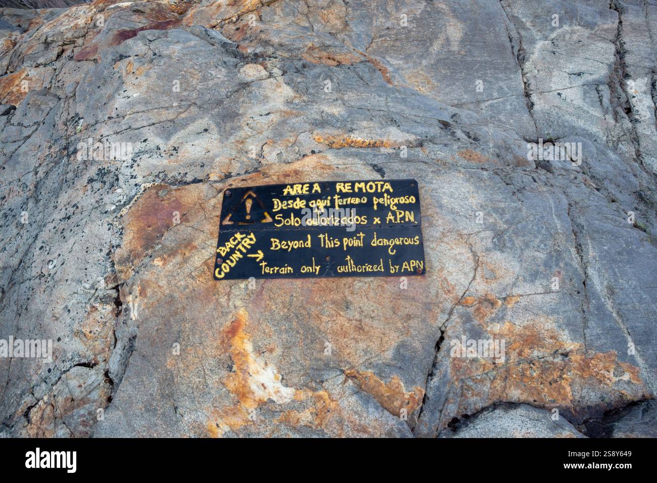 Warning sign in the wild region in Patagonia to warn individual trekkers: only with local guides to enter the risky area Stock Photo