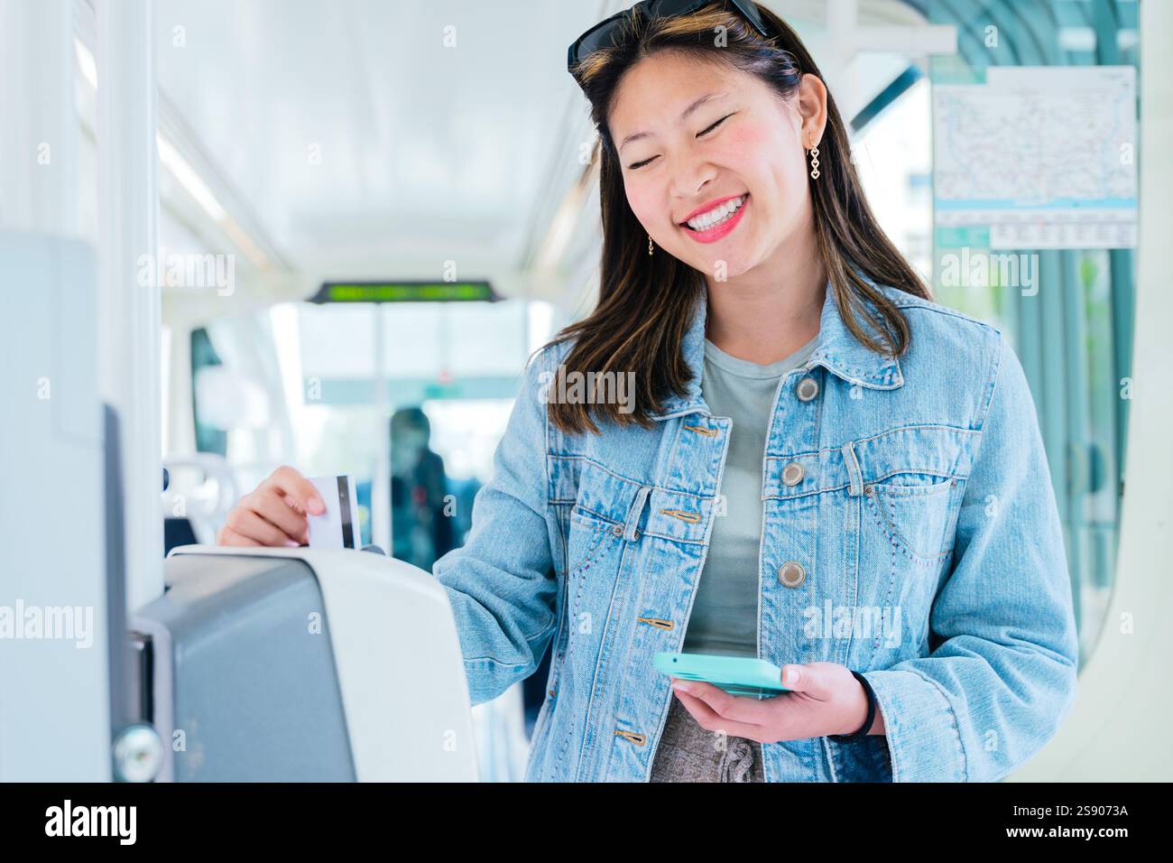 Smiling Young Woman Validating Ticket Inside Public Transport Holding ...