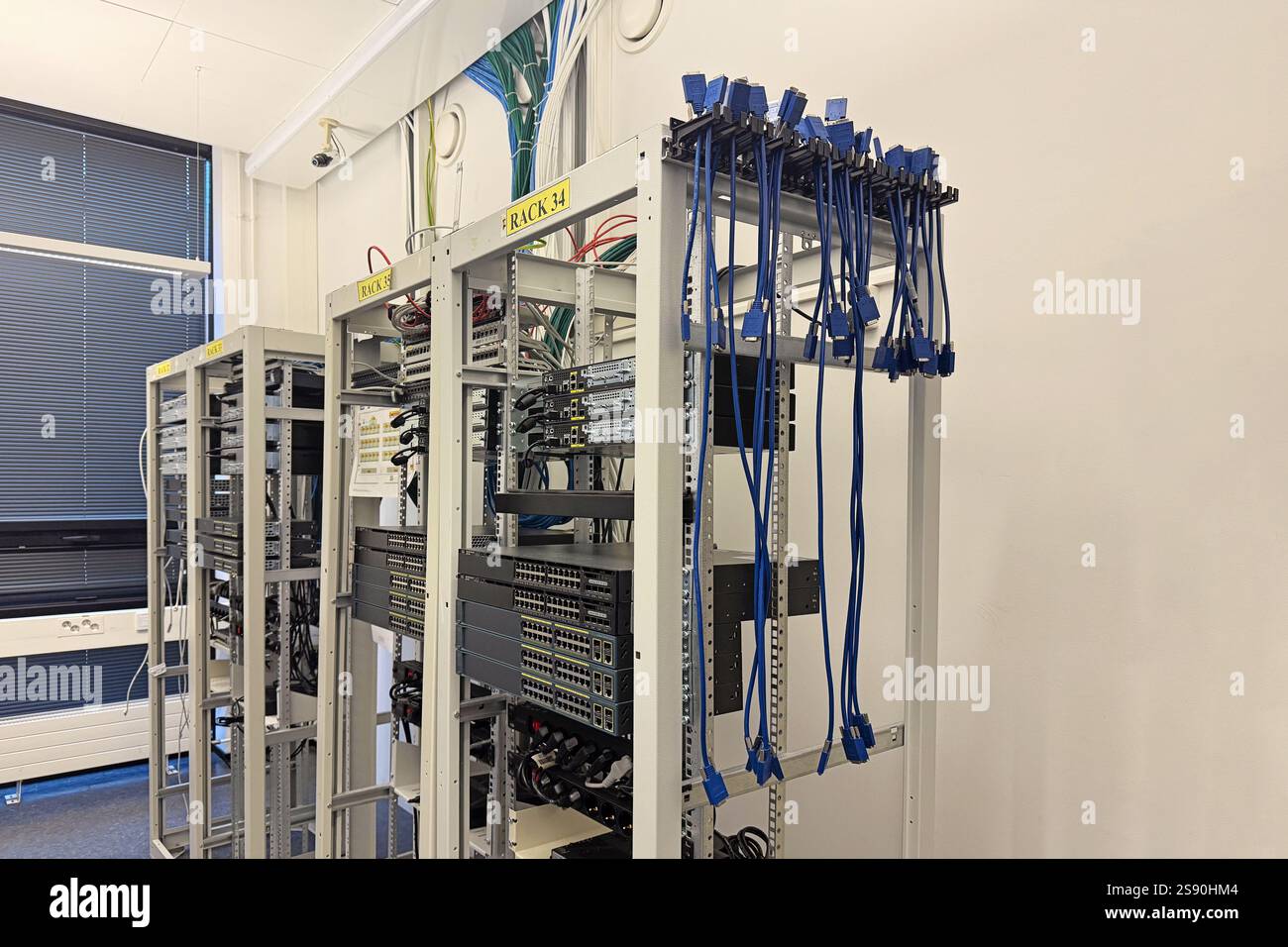 Racks and network cables in high-tech office. Infrastructure, networking, and data storage concept Stock Photo