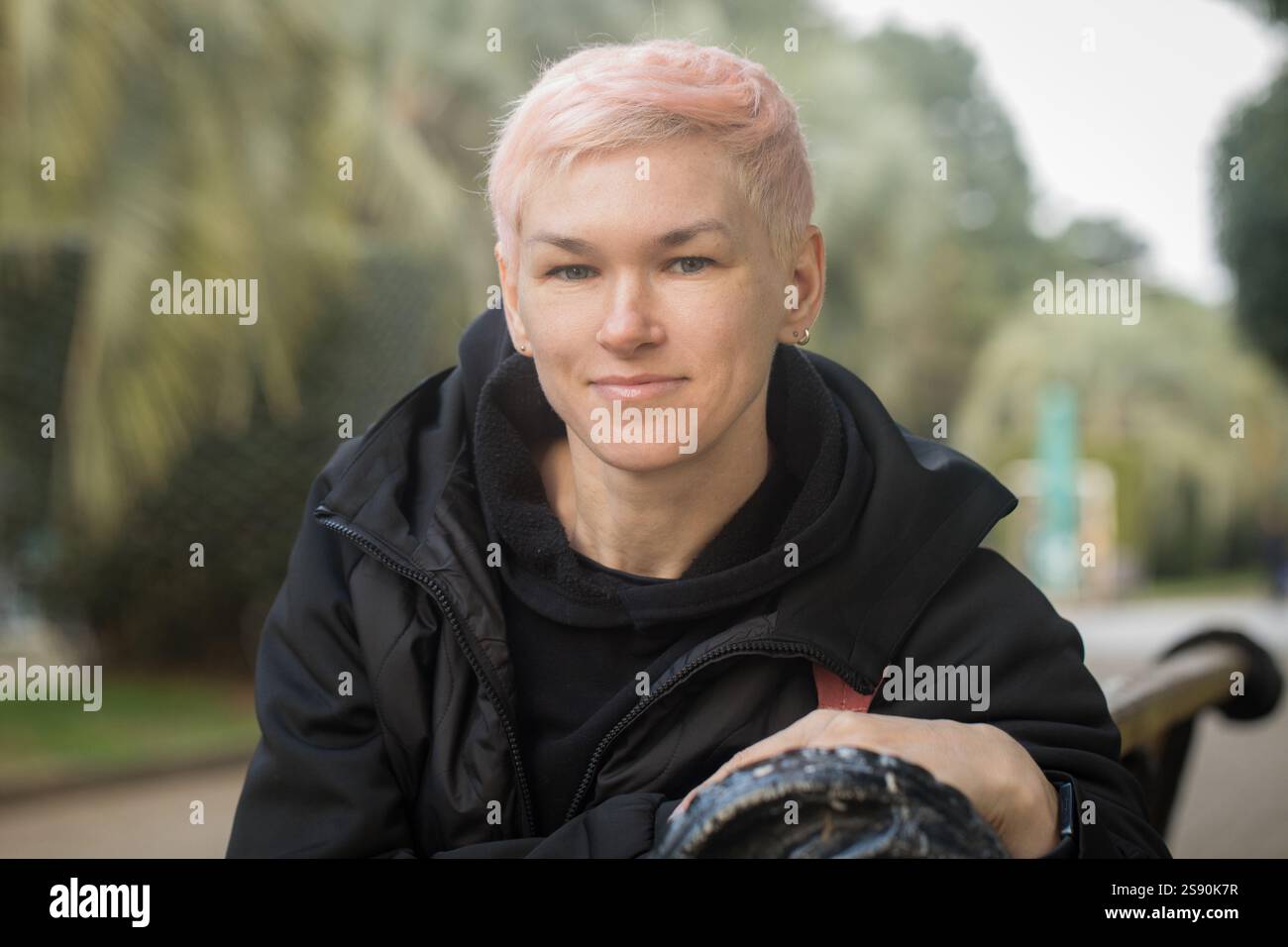 Attractive mature woman sitting on a park bench Stock Photo - Alamy