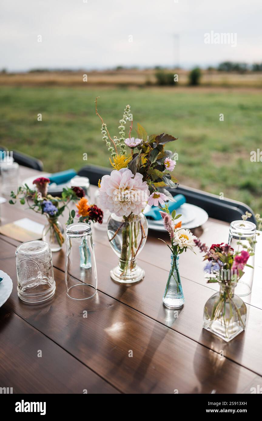 Bud vases on a wooden table outside Stock Photo