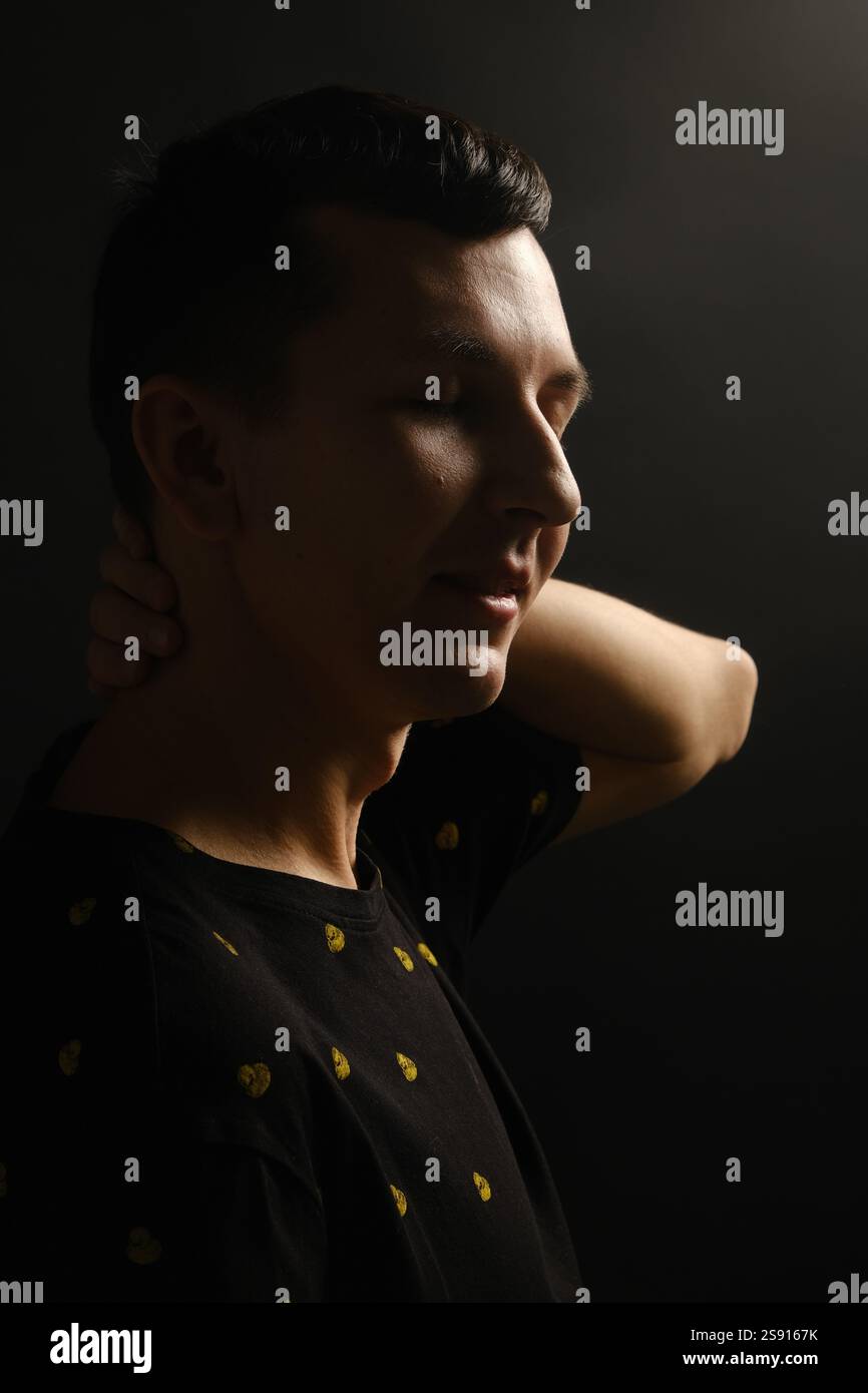 A young man stands illuminated by striking lighting Stock Photo