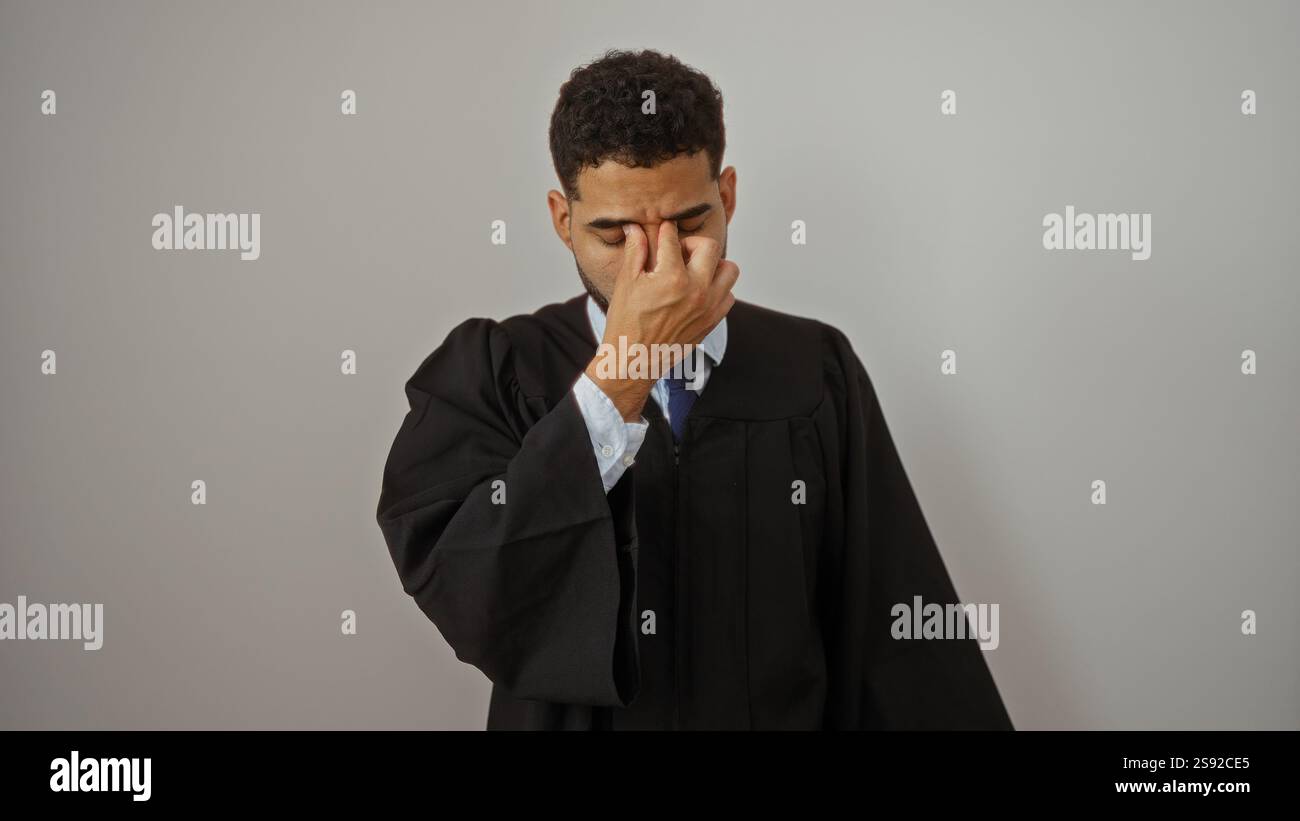 Hispanic man wearing judge robe stands over white background appearing ...