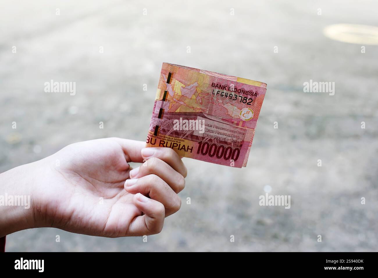 One Hundred Thousand Rupiah Indonesian banknotes are held by women ...