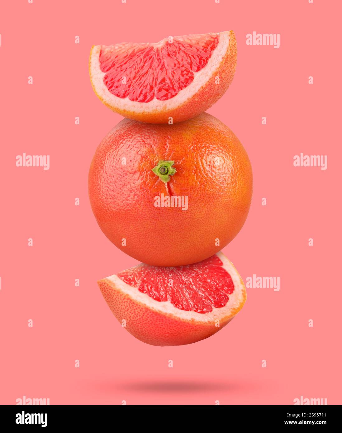 Fresh grapefruits in air on pink background Stock Photo
